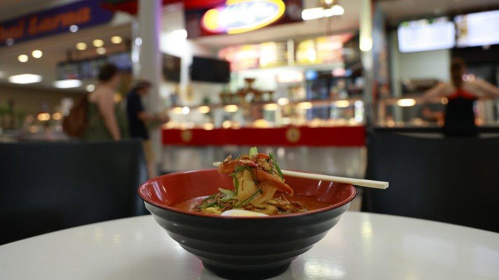 A bowl of laksa in front of Chok's Place