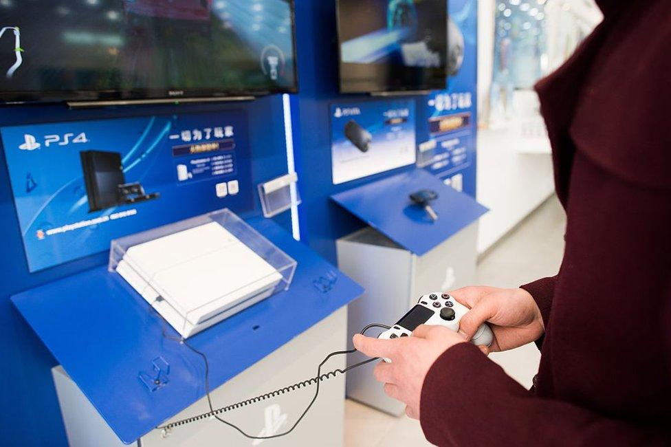 A person playing a Sony PlayStation 4