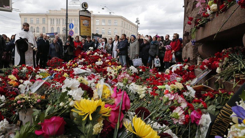 A priest prays outside Tekhnologichesky Institut metro station where people are paying tribute to victims of an explosion on St Petersburg metro, Russia, 5 April 2017