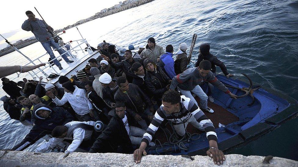 A boat carrying Tunisian migrants enters the port of Lampedusa