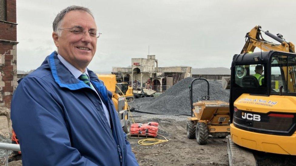 Jonathan Brook, Lib Dem leader of Westmorland and Furness Council, stands in front of continuing restoration work at Grange Lido