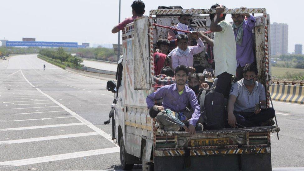 Migrant workers headed back to their towns and villages hitch a ride, on day 5 of the nationwide lockdown imposed by PM Narendra Modi to check the spread of coronavirus, at Yamuna expressway zero point, on March 29, 2020 in Noida, India