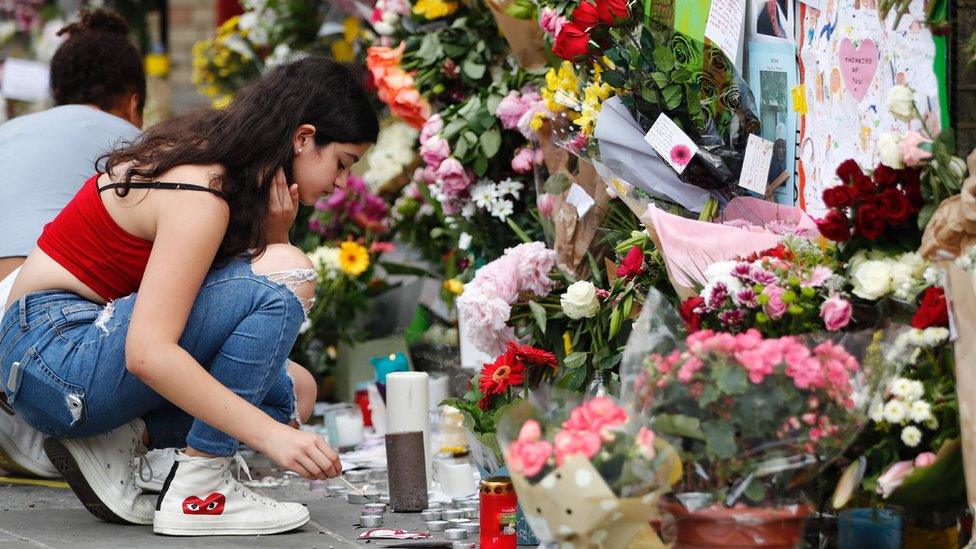 A girl lights a candle outside Notting Hill Methodist Church in west London