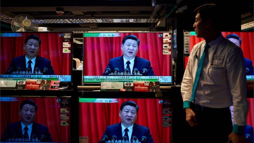 Image shows television sets showing a news report on China President Xi Jinping's speech