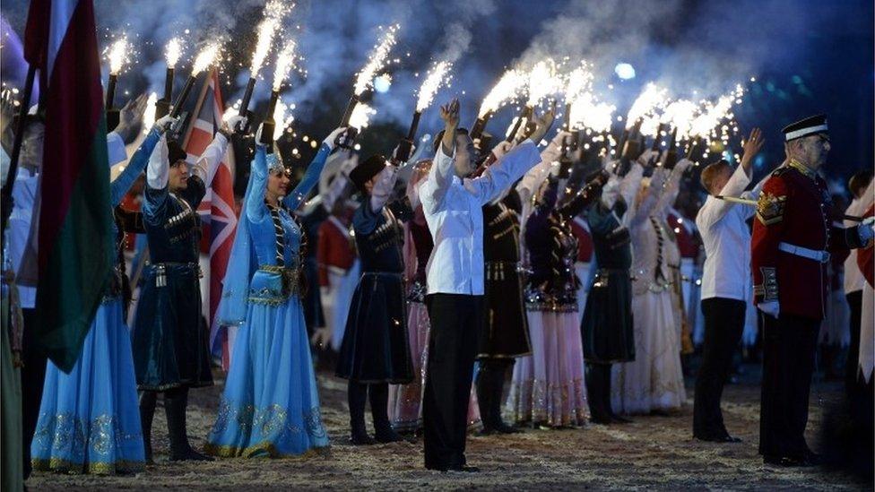 Performers raise their arms