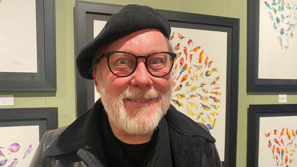 Jim Moir in front of his art works