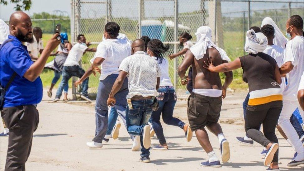 Haitian migrants try to return to the airplane used by U.S. authorities to fly them out of a Texas border city after crossing the Rio Grande river from Mexico, at Toussaint Louverture International Airport in Port-au-Prince, Haiti September 21, 2021.