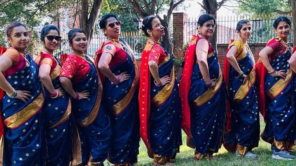 A row of women in matching sarees