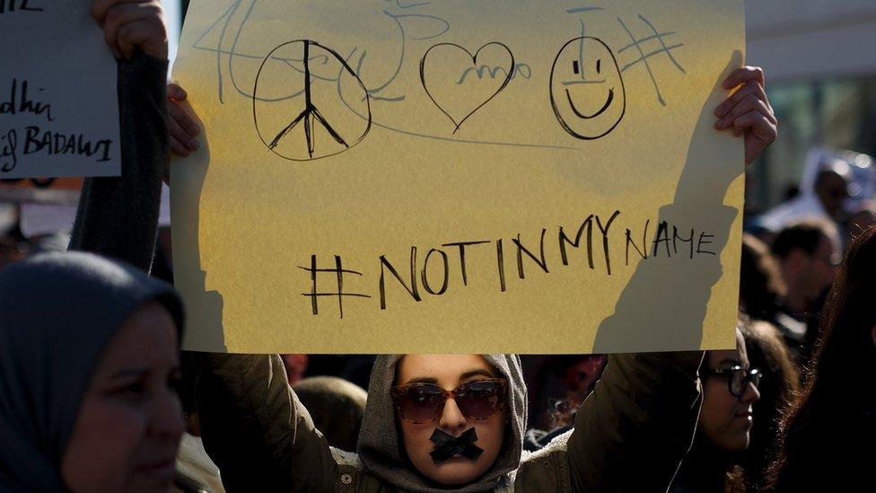 A protester holds a placard reading 'Not in my name' during a demonstration in Spain against the Charlie Hebdo attack in Paris in January