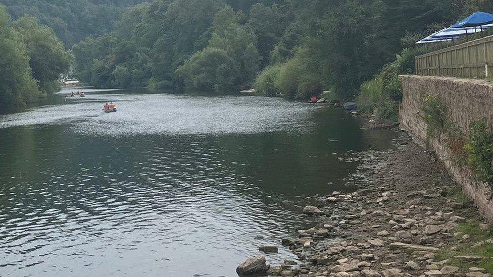 Rocks on the riverbed with a boat in the distance