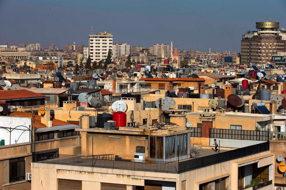 A boy plays football on a Damascus rooftop, 28 February