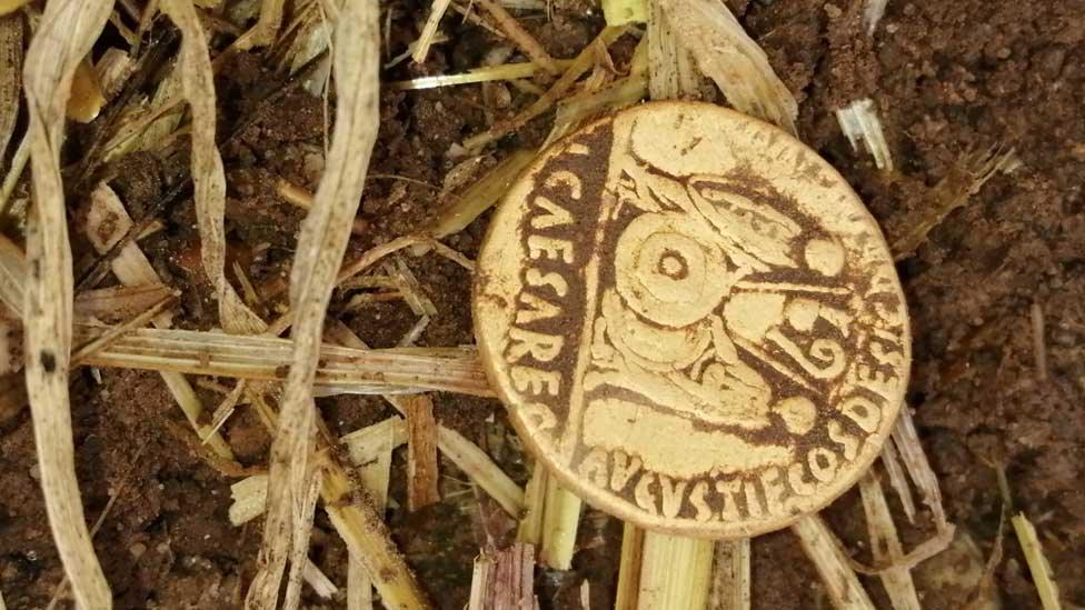 Gold Roman coin as it was unearthed