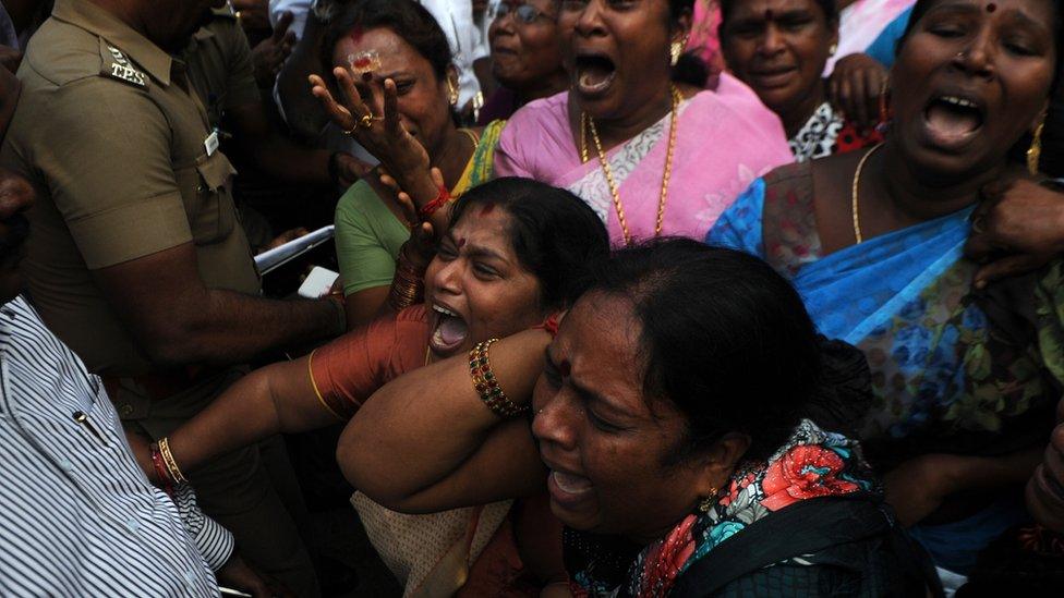 Indian supporters of the Chief Minister of Tamil Nadu Jayalalithaa Jayaram react outside the hospital where she is being treated after false reports that she had died in Chennai