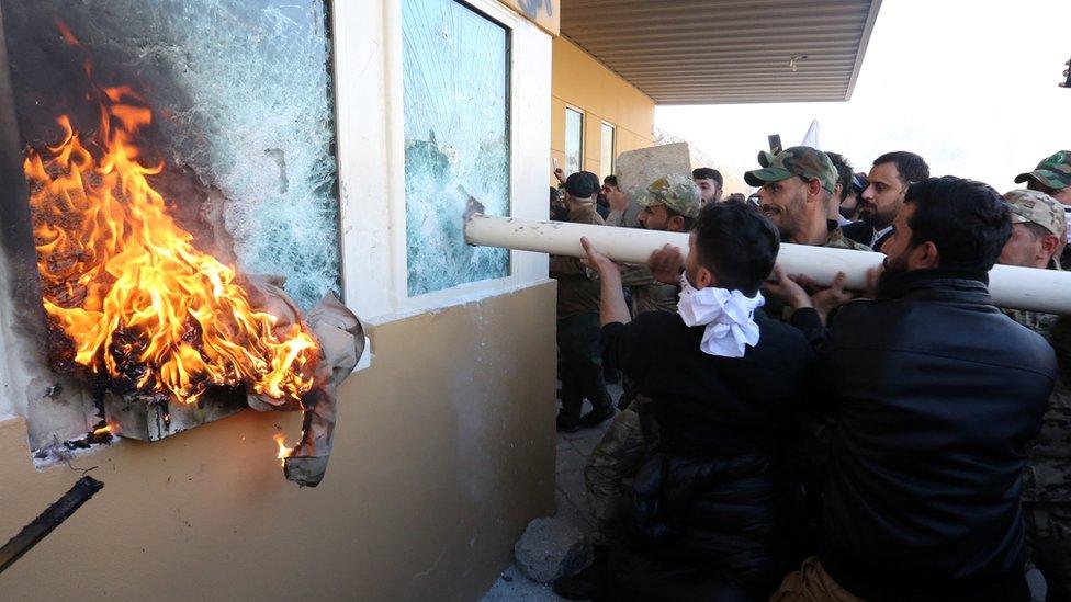 Members of Iraqi Shia "Popular Mobilisation Forces" armed group and their supporters attack the entrance of the US embassy in Baghdad, 31 December 2019