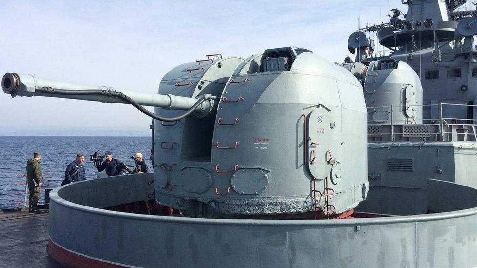 Journalists walk around a destroyer warship