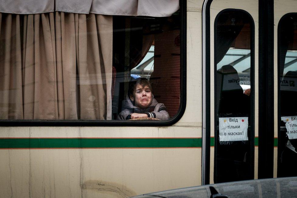 A young boy leaves Ukraine on a bus bound for Poland. Thousands of children have spent hours away from home.