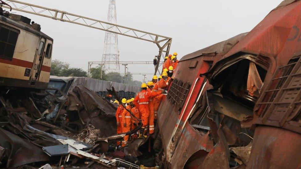 Emergency service personnel get inside an overturned train carriage