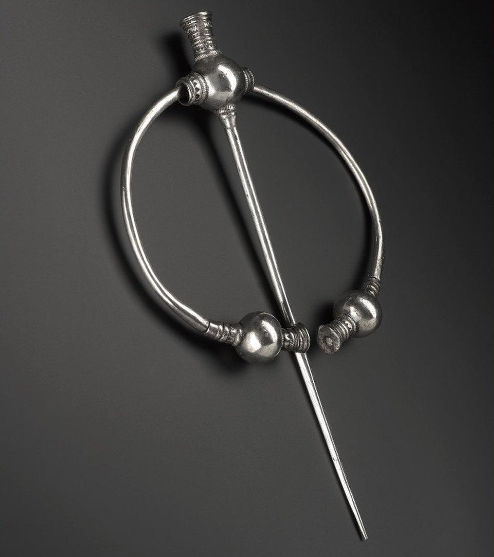 Penannular silver brooch with thistle terminals, the balls undecorated, with a series of mouldings on either side, from Skaill.jpeg