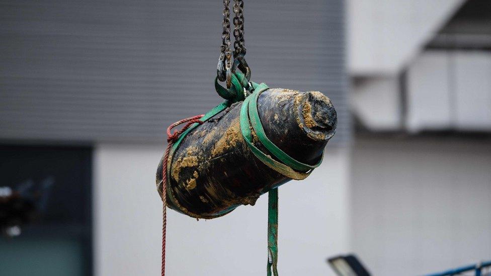 A defused US-made bomb dropped during World War II is lifted by crane