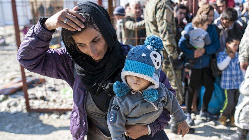 Migrants and refugees prepare to board a train heading to Serbia from the Macedonian-Greek border near Gevgelija on 25 October 2015