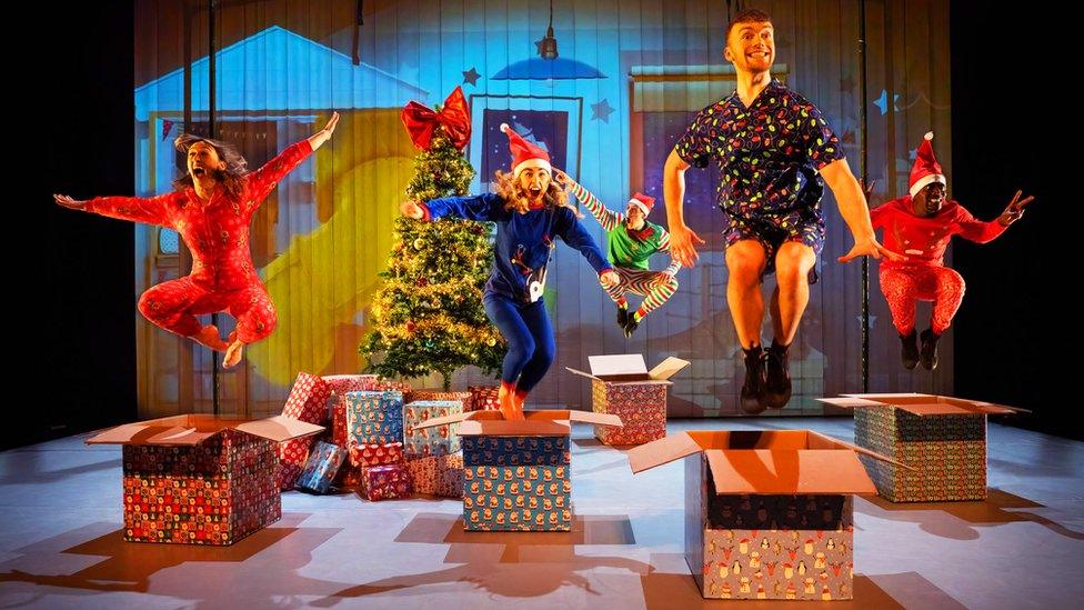 Cast members jump up in the air ahead of the Christmas show