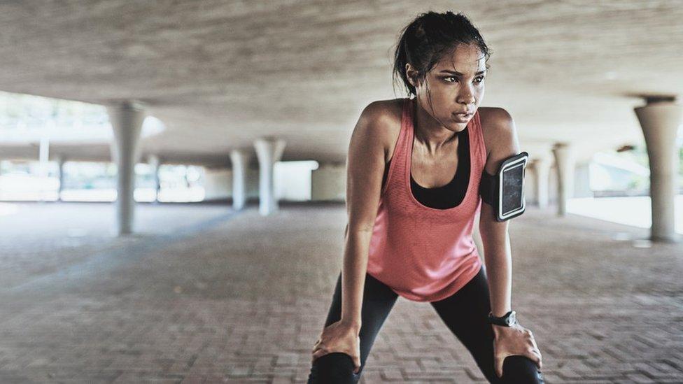 Picture of a young woman working out with a fitness tracker on her arm