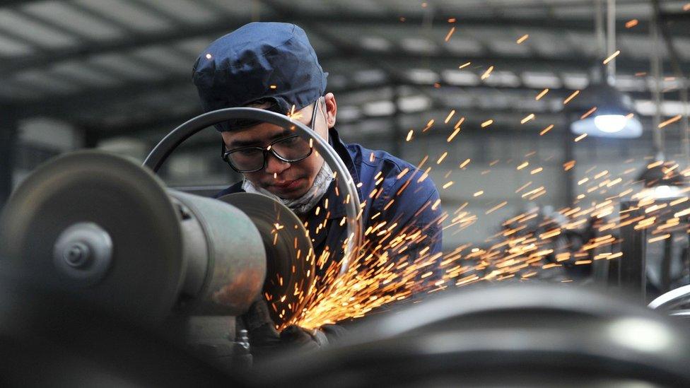 A worker welds wheel hubs of baby carriages that will be exported at a factory in Hangzhou in China's eastern Zhejiang province on June 4, 2018