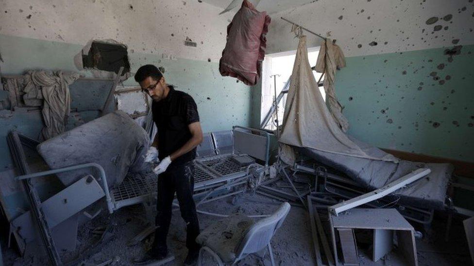 A Palestinian employee inspects damages at the al-Aqsa hospital in Deir al-Balah