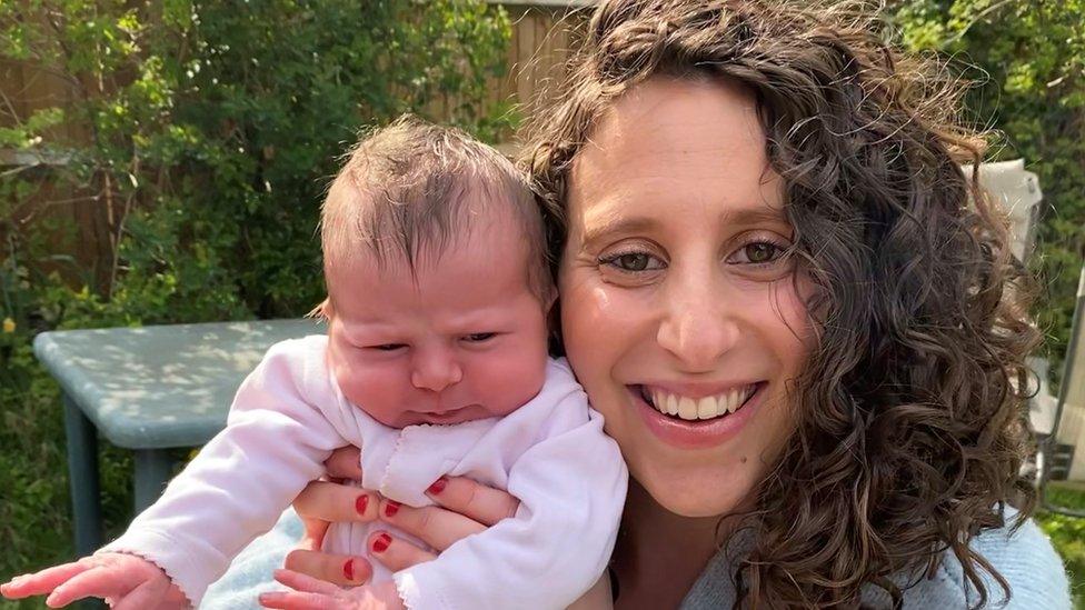 Victoria White holds up her newborn daughter