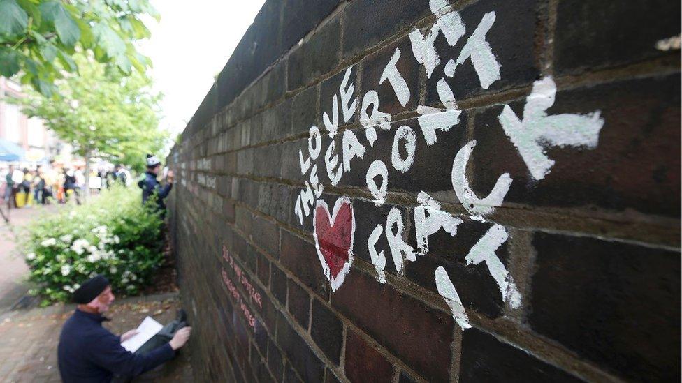 Anti-fracking protester (demonstrator) writes messages on a wall with chalk during a demonstration in England