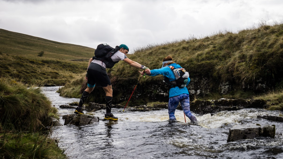 Rhedwyr yn cefnogi ei gilydd drwy'r afon