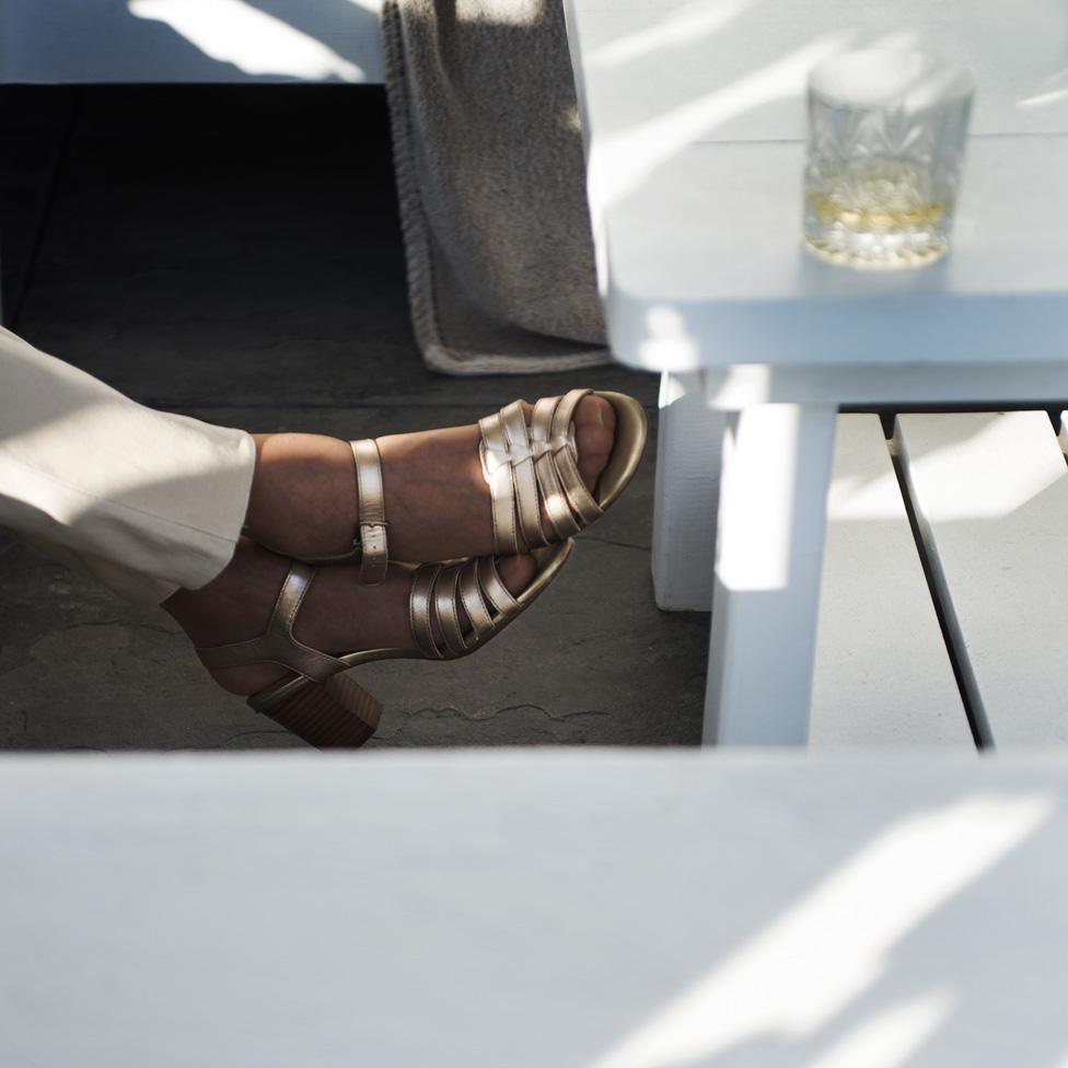 Close up of feet in gold sandals