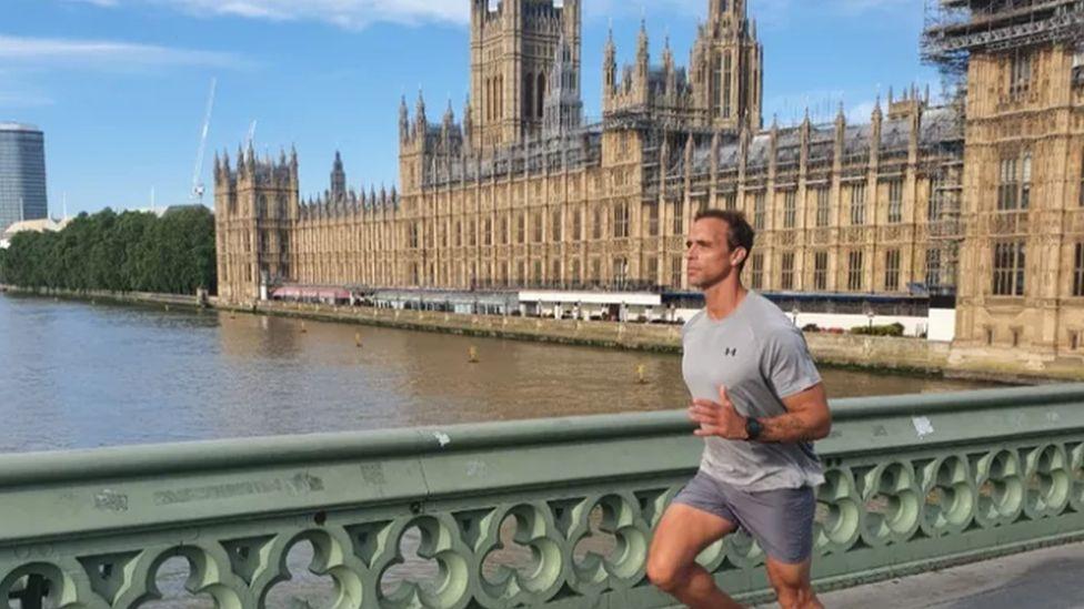 Paul Minter running across a bridge