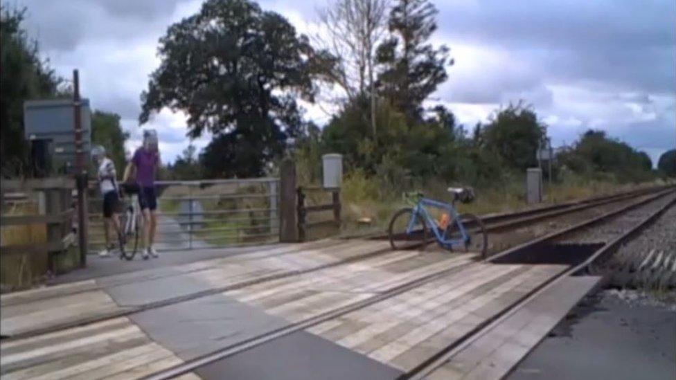 Bike wedged in between train tracks at a level crossing