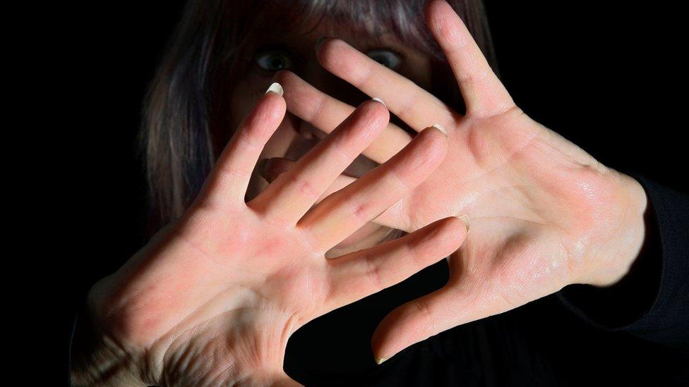 Scared women shielding her face