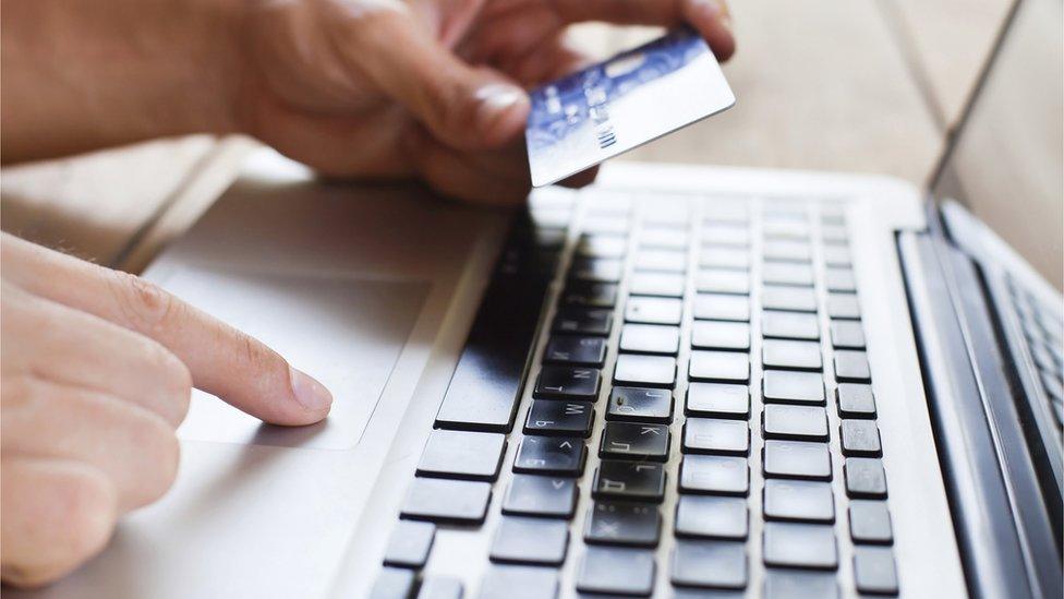 Person at computer with credit card