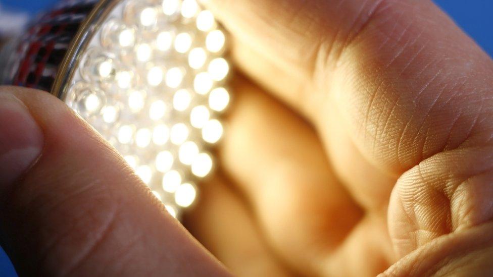 Man holding LED light bulb