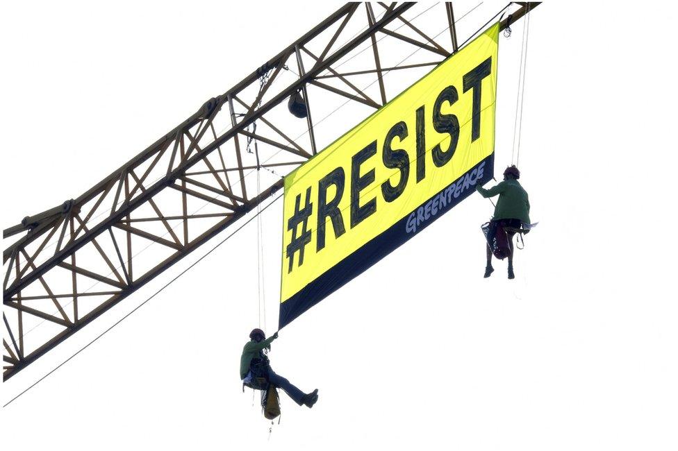 Greenpeace activists unfurl a banner reading "Resist" in Brussels, 25 May