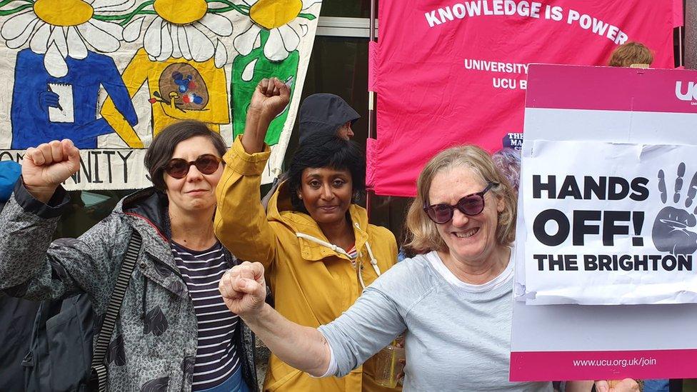 Kate Aughterson and two friends holding placards at the protest