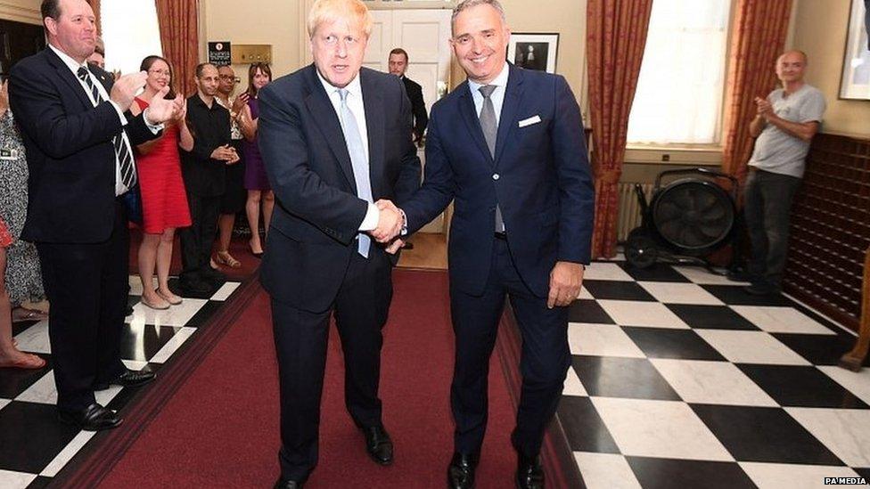 Boris Johnson being welcomed to Downing Street by Sir Mark Sedwill, with Dominic Cummings applauding him in the background (right)