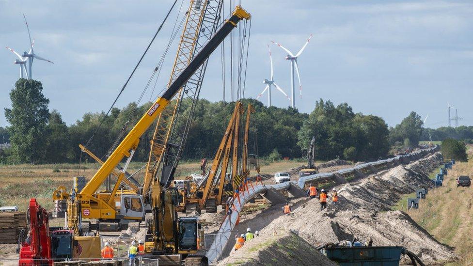 Workers construct a pipeline for transporting natural gas