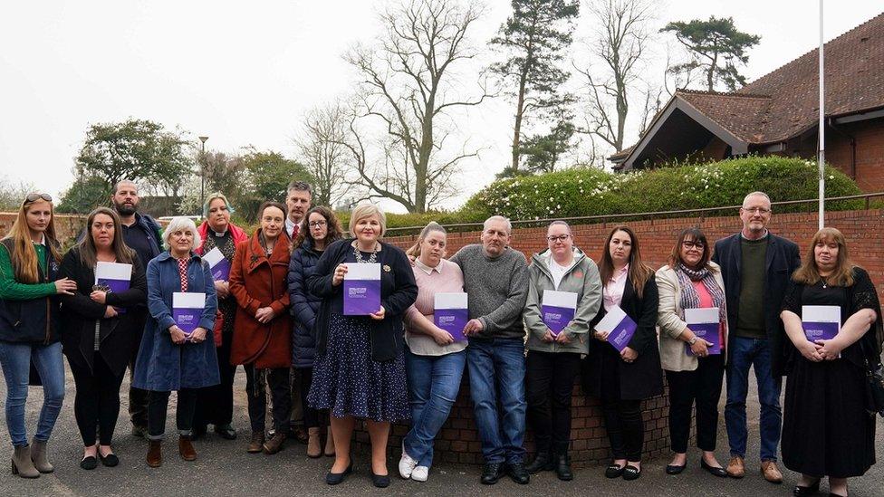 Chelsey Campbell, Carley McKee, Colin Griffiths, Fiona Carr, Charlotte Cheshire, Rhiannon Davies, Richard Stanton, Kayleigh Griffiths, Donna Ockenden, Nicky Lauder, David Boylett, Hayley Matthews, Steph Hotchkiss, Julie Rawlings, Neil Rawlings and Sonia Leigh stand with the final Ockenden report at The Mercure Shrewsbury Albrighton Hotel, Shropshire.