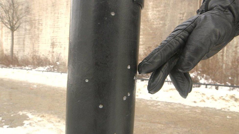 Shrapnel marks on a lamp post after a grenade explosion in Stockholm