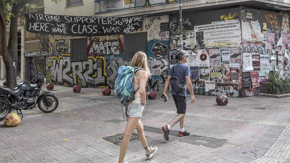 A banner displayed in central Exarchia tells tourists they are "targets" and to "go home"