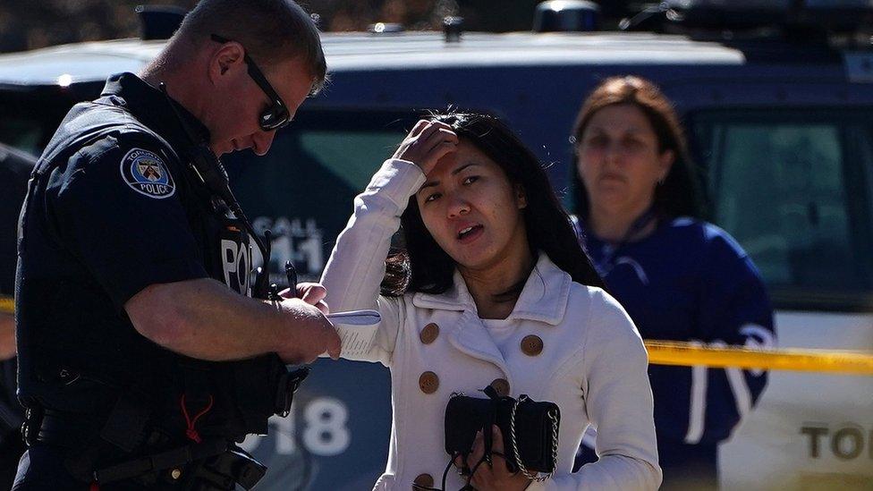 A witness speaks to a police officer at the scene of an incident where a van struck multiple people on Yonge Street in Toronto, Ontario, Canada April 23, 2018