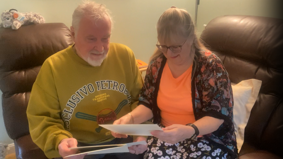 Paul and Maggie Cook looking at wedding photos