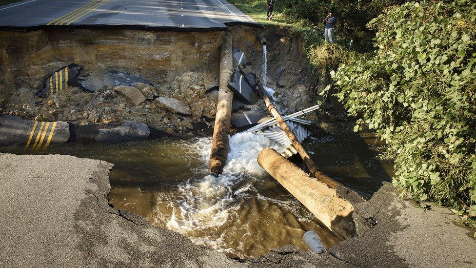 People look at Bingham Drive in Fayetteville, NC, on Sunday, Oct. 9, 2016, after it was washed away by flood waters from Hurricane Matthew.