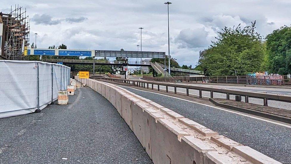 Bollards and signs alerting motorists to the partial closure of the road