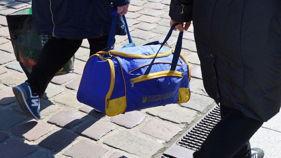 Two Ukrainian refugees holding a Ukraine bag