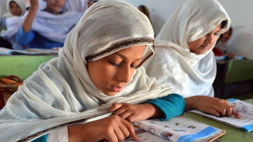 Pakistani female students attend a class at a government school in Peshawar (October 2012)